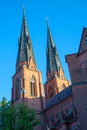 The twin towers, in french gothic style, of the Uppsala cathedral Ã¢â¬â halfway lit by the rising sun an early summer morning.